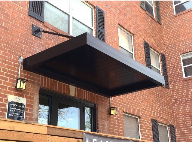 Black metal canopy over an apartment building entrance